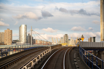 Obraz na płótnie Canvas London, UK. Canary Wharf DLR light rail way track and station at sunset
