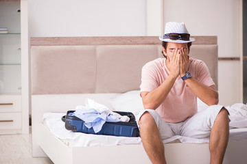 Man with suitcase in bedroom waiting for trip 