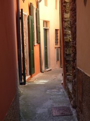 Colorful narrow street in Telaro italy with sunlight at the end beckoning you to explore.