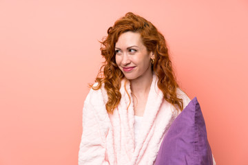 Redhead woman in dressing gown standing and looking to the side