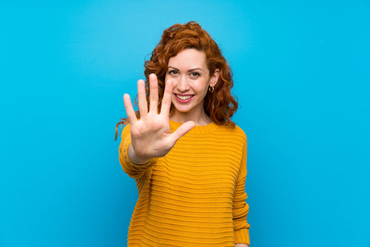 Redhead woman with yellow sweater counting five with fingers