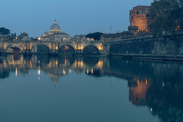 River Tiber in Rome and St Peters Cathedral at night. Reflections in the water of illuminated...