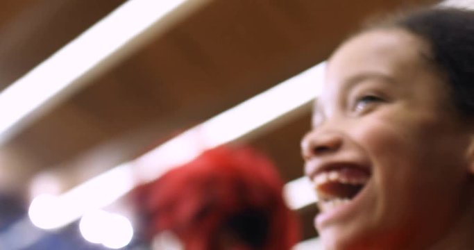 Young girl jumps up to celebrate her team scoring a point at a basketball match