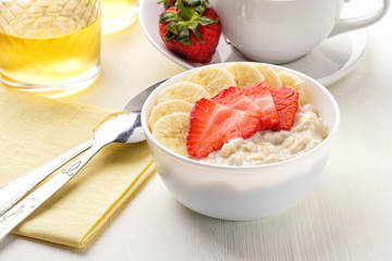 Bowl of breakfast muesli decorated with banana, strawberry slices and chia seed