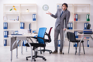 Leg injured male employee working in the office 