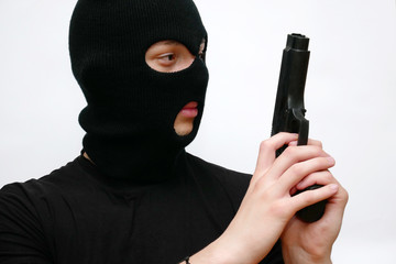 Criminal man, terorist in black mask balaclava with gun on white background.