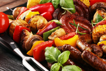 Assorted delicious grilled meat and skewer with vegetable on rustic table