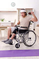 Injured young man doing exercises at home 