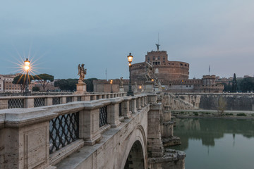 Lateral view Stone bridge with historic illumination over the Tiber at dawn. Aurelius bridge with...