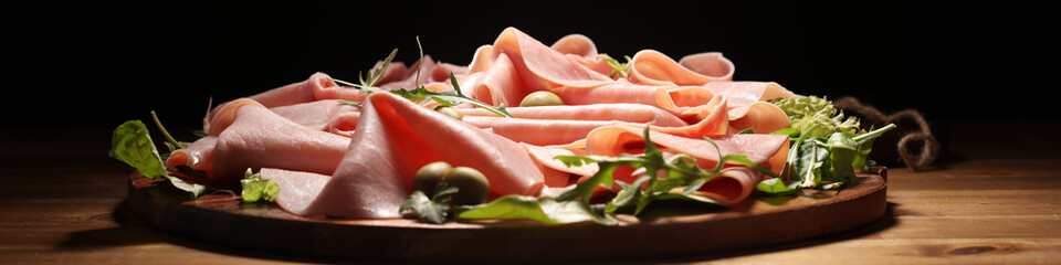 Sliced ham on wooden background. Fresh prosciutto. Pork ham proscuitto sliced.