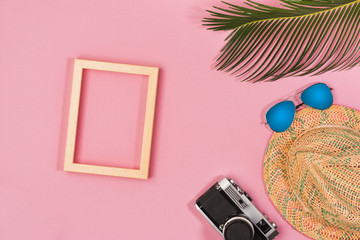 Summer vacation concept. stylish sunglasses, retro photo camera and green palm leaves on pink background, flat lay. space for text