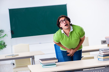 Male student suffering from urge in the classroom  