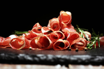 Italian sliced cured coppa with spices. Raw ham. Crudo or jamon with rosemary