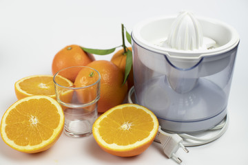 sliced ​​oranges and juicer with white background