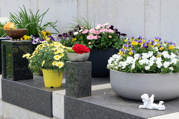 Am Friedhof, frühlingshaft geschmückte Urnengräber