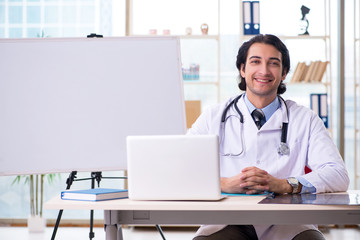 Young handsome doctor in front of whiteboard 