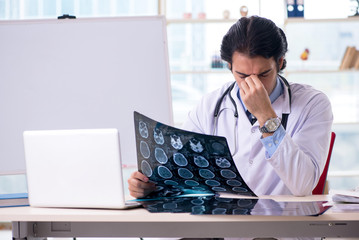 Young handsome male radiologist in front of whiteboard 