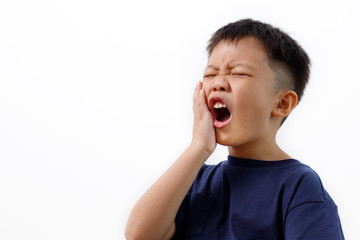 Asian kid suffering from toothache pain, holding his cheek, isolated on white background. Dental Health And Care Concept.