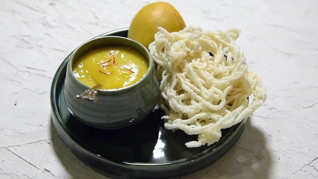 Aam Ras or Alphonso mango pulp with kurdai which is a fried dish made using wheat/gehu. selective focus