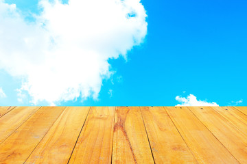 Old Wooden table with blue sky white cloud background.