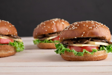 fried champignons, lettuce, tomato and cheese in mushroom burger, blurred background