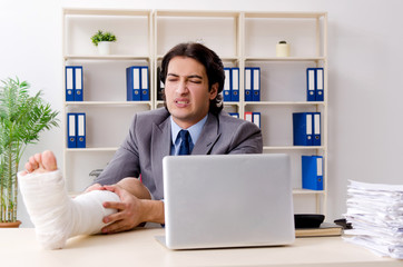 Leg injured employee working in the office 