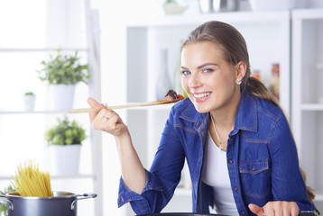 Young woman cooking healthy food holding a pan with vegetables is it. Healthy lifestyle, cooking at home concept