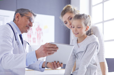 Portrait of a cute little girl and her doctor at hospital