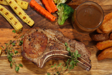 Close up of Pepper T-bone steak served with grilled vegetables on the table in restaurant. Good view of Pub & restaurant concept.