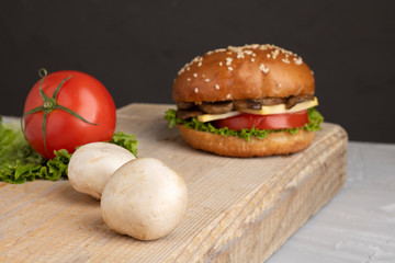 crispy vegan mushroom burgers with marzipan cheese, tomato and salad leaves,baked bun with sesame 