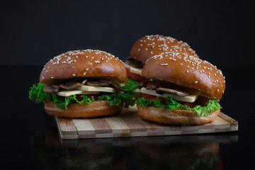 crispy vegan mushroom burgers with marzipan cheese, tomato and salad leaves,baked bun with sesame 