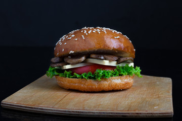 crispy vegan mushroom burgers with marzipan cheese, tomato and salad leaves,baked bun with sesame 