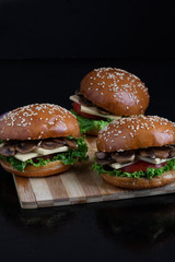 crispy vegan mushroom burgers with marzipan cheese, tomato and salad leaves,baked bun with sesame 