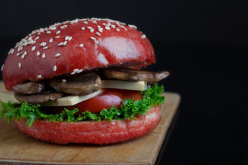 red crispy vegan mushroom burgers with marzipan cheese, tomato and salad leaves,baked bun with sesame 