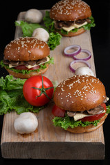 crispy vegan mushroom burgers with marzipan cheese, tomato and salad leaves,baked bun with sesame 