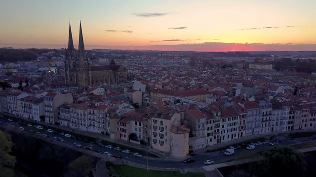 Bayonne cathedral at sunrise surrounded by medieval half timbered houses, orange red sky in France aerial view