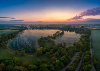 Fototapeta na wymiar Early morning sunrise as an aerial with a lake as main motive.