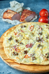 Slice of hot pizza large cheese lunch or dinner crust seafood meat topping sauce. with bell pepper vegetables delicious tasty fast food italian traditional on wooden board table classic in view