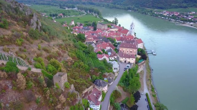 Aerial circling and fly over view of medieval Durnstein castle ruin and town in Wachau valley Lower Austria along the river Danube