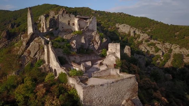 Aerial circling and fly over view of medieval Durnstein castle ruin and town in Wachau valley Lower Austria along the river Danube