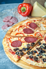 Slice of hot pizza large cheese lunch or dinner crust seafood meat topping sauce. with bell pepper vegetables delicious tasty fast food italian traditional on wooden board table classic in view