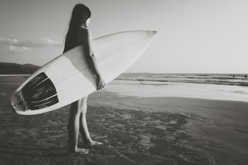 Nostalgia and remembrance photo of surfer woman in bikini go to surfing. beautiful sexy woman with surfboard on beach. black and white color tone.