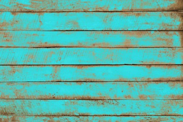 Old weathered wooden plank painted in turquoise blue color. Vintage beach wood background.