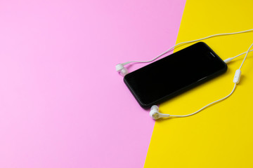 Smartphones and headphones Listen to vintage music on a yellow and pink background.