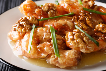 Deep fried honey prawns with caramelized walnuts and spring onions close-up. horizontal