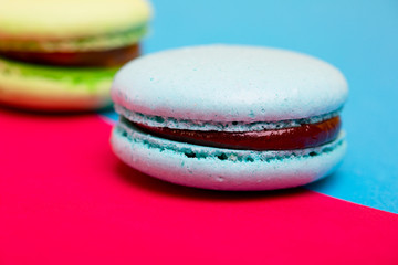Tasty different colored macarons on multicolored background