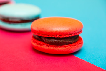 Tasty different colored macarons on multicolored background