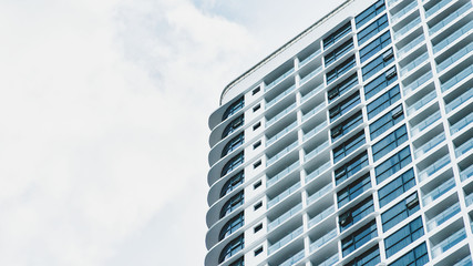 Fototapeta premium modern high-rise multi-storey hotel building on the background of a beautiful blue cloudy sky. copy space for your text