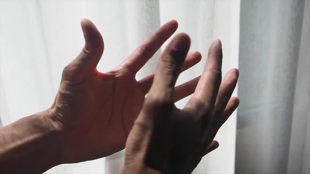 Male hands movement near the window with warm beautiful sunlight from outside. Image of artificial arm checking for it's movement after operation.