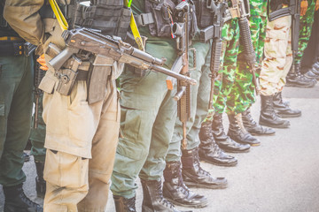 Soldier, commando standing, prepare for protection in row and hold gun in hand. Vintage style Tone